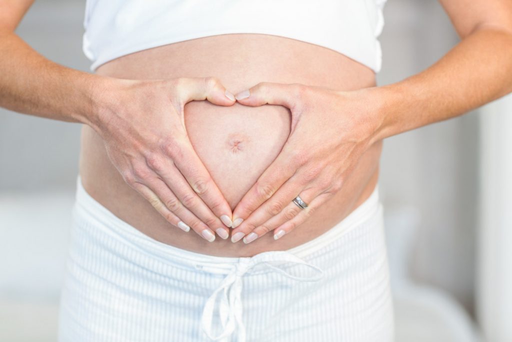 pregnant woman holding hands on belly